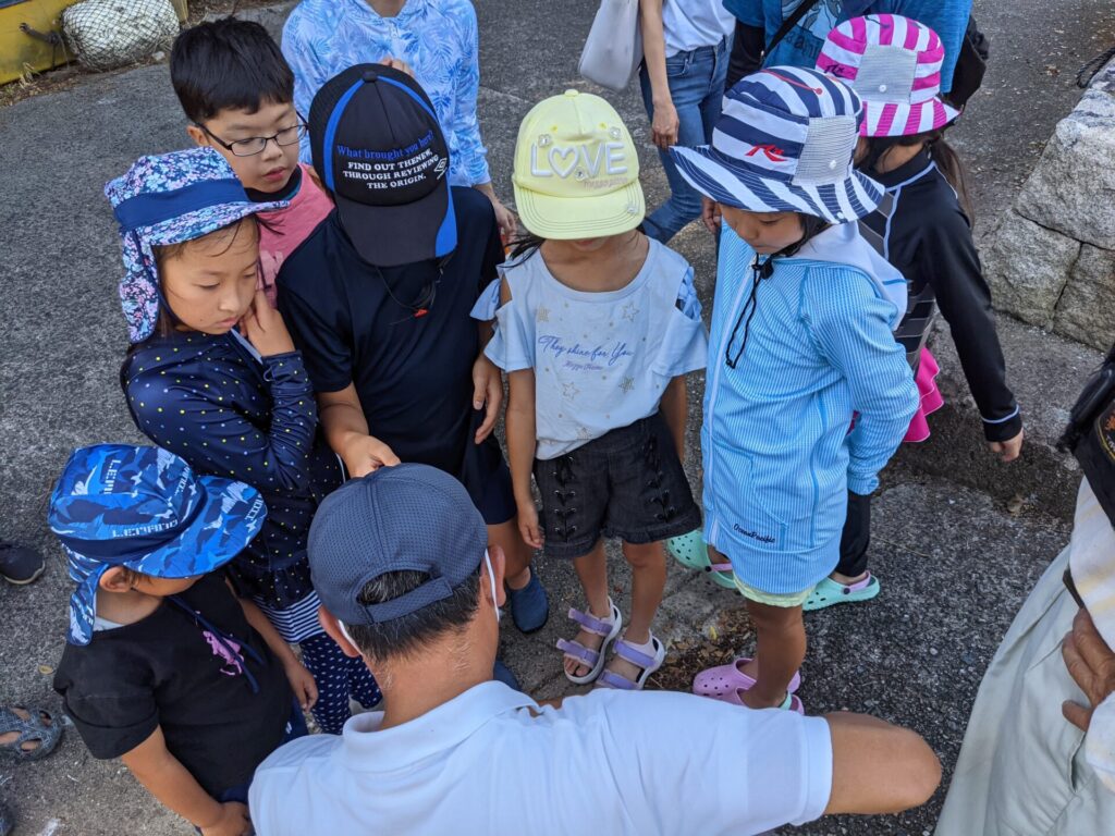 漁業体験で説明を聞いている場面